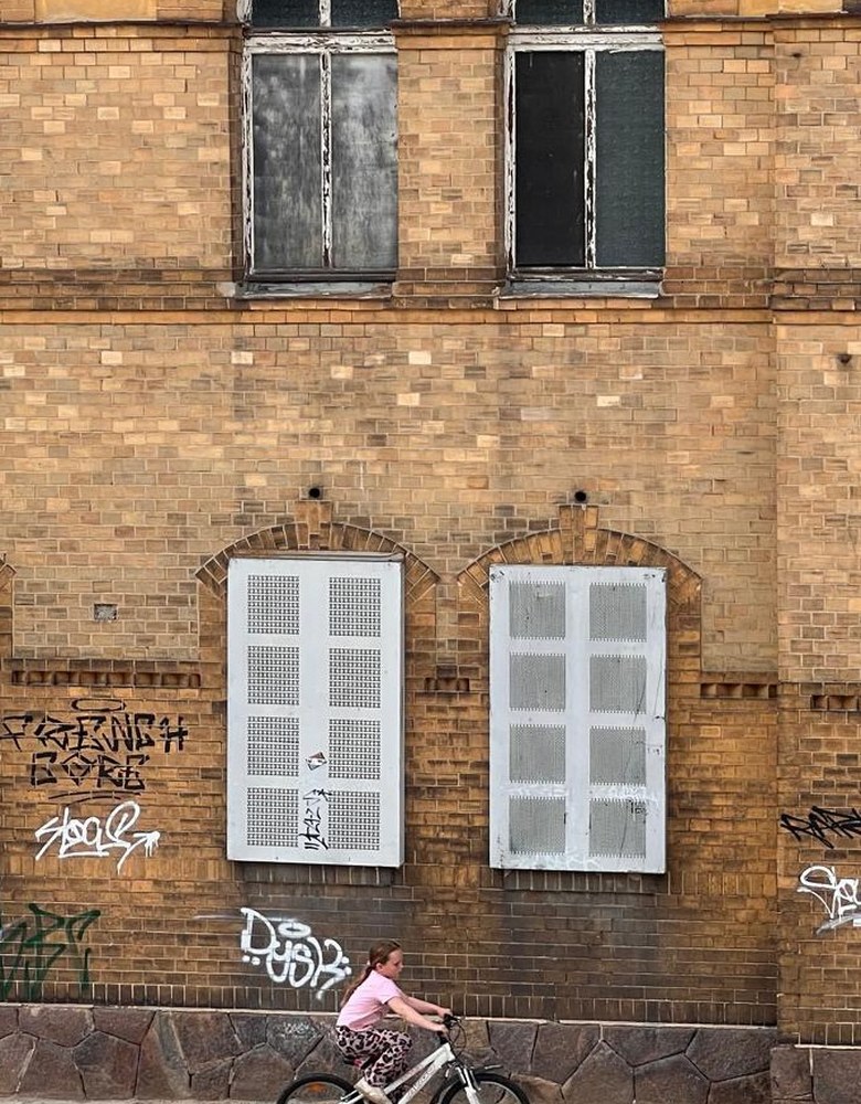 Fassade des Stadtbads Glauchau mit Fahrradfahrerin